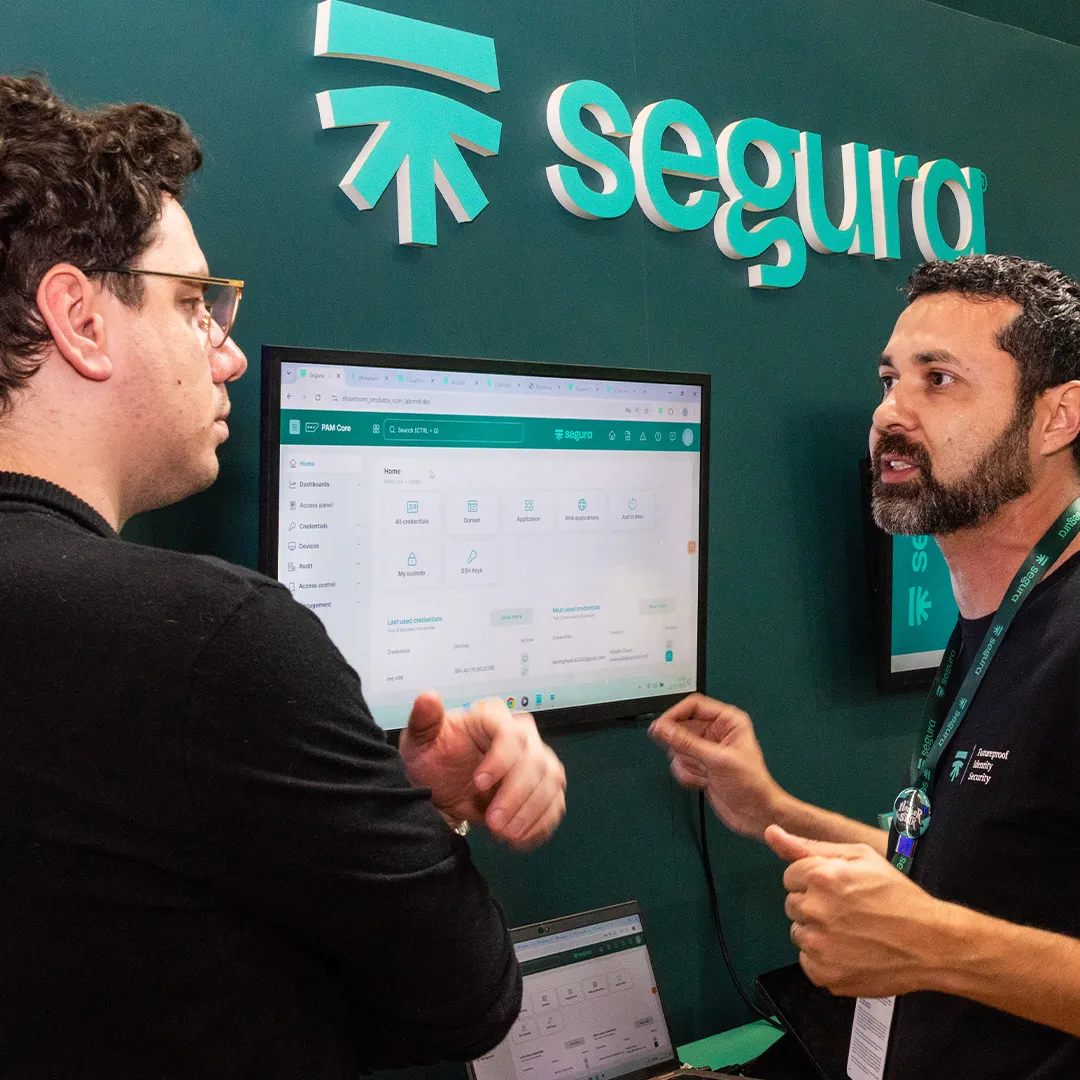 Segura™ specialist demoing the platform on a screen to a visitor at the Segura™ booth