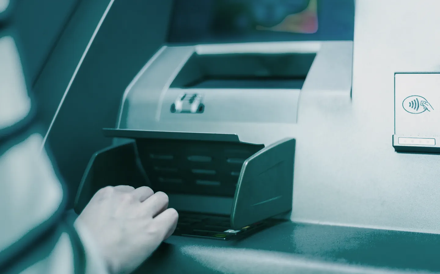 Hand at the cash slot of a bank ATM