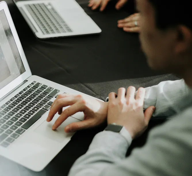 Mãos de um profissional digitando em um notebook