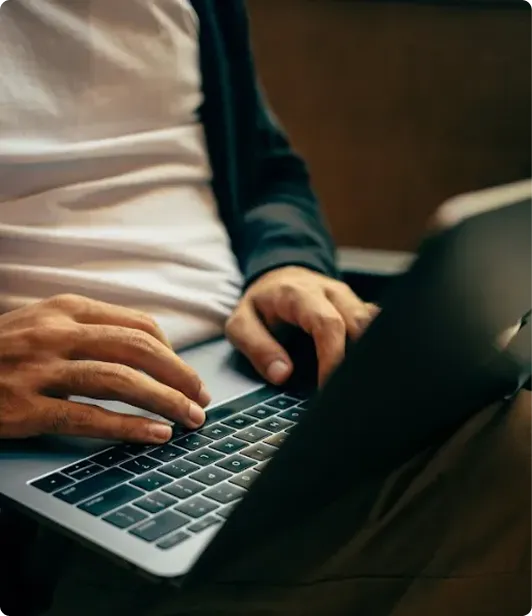 Hands typing on a laptop keyboard