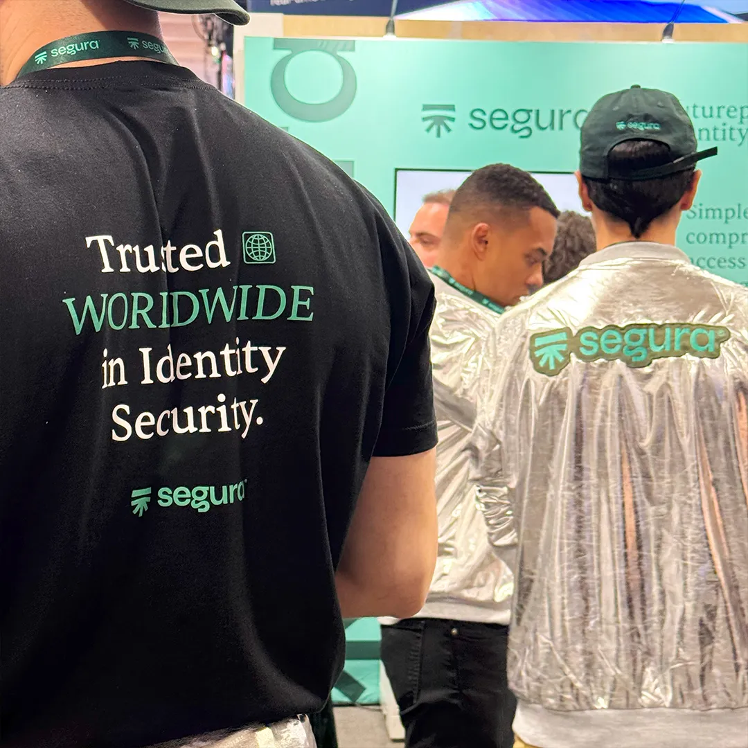 Segura™ team member in a “Trusted worldwide in identity security” T-shirt beside colleagues in silver jackets