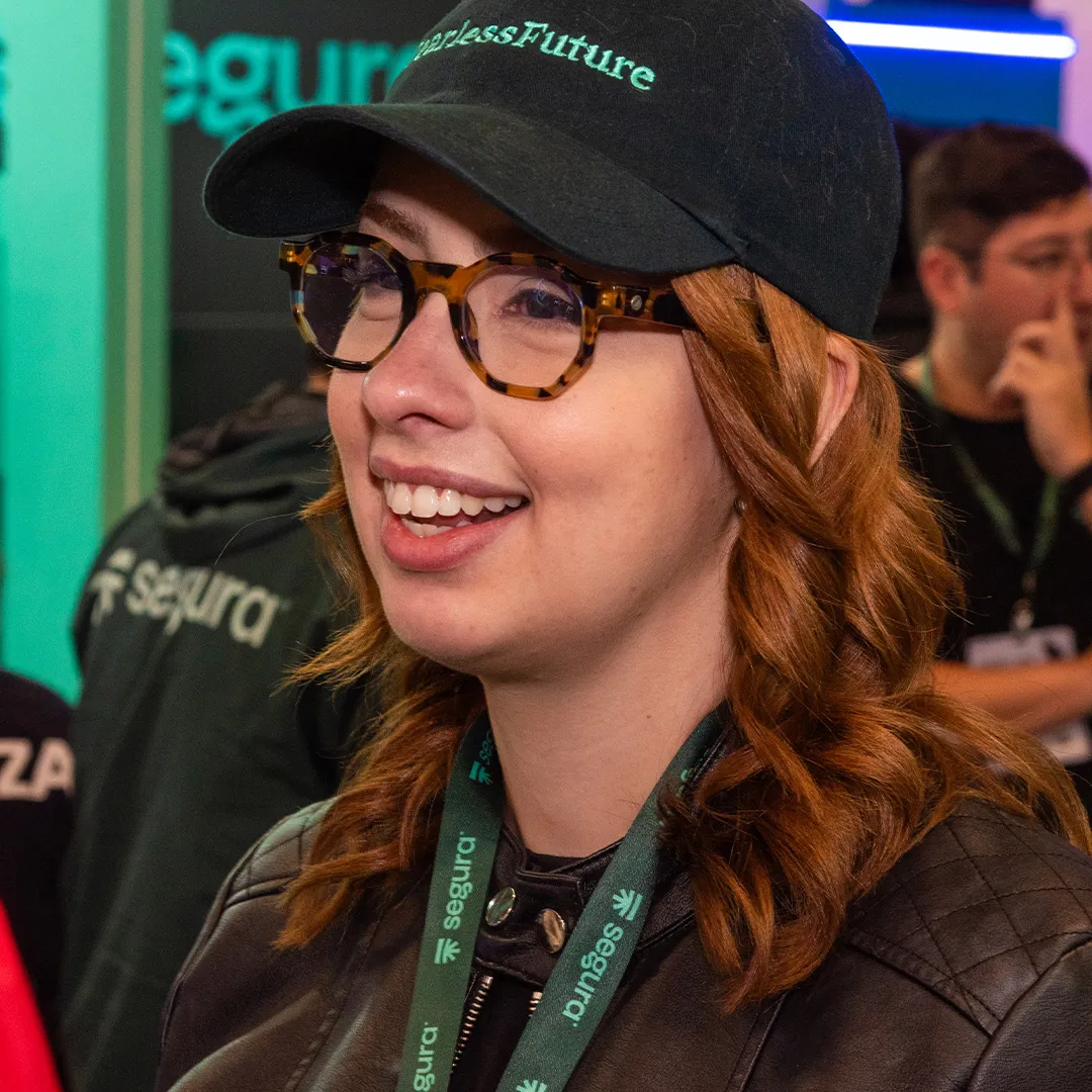 Smiling woman in a Segura™ cap at the Segura™ booth